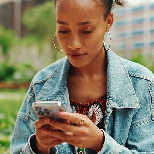 Image of women reading a text from a scammer impersonating the UPS.