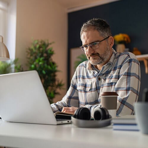Image of a man reviewing his credit report on his laptop and seeing an unauthorized hard inquiry.