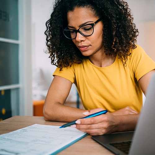 A person fills out their tax return early to avoid potential tax fraud.